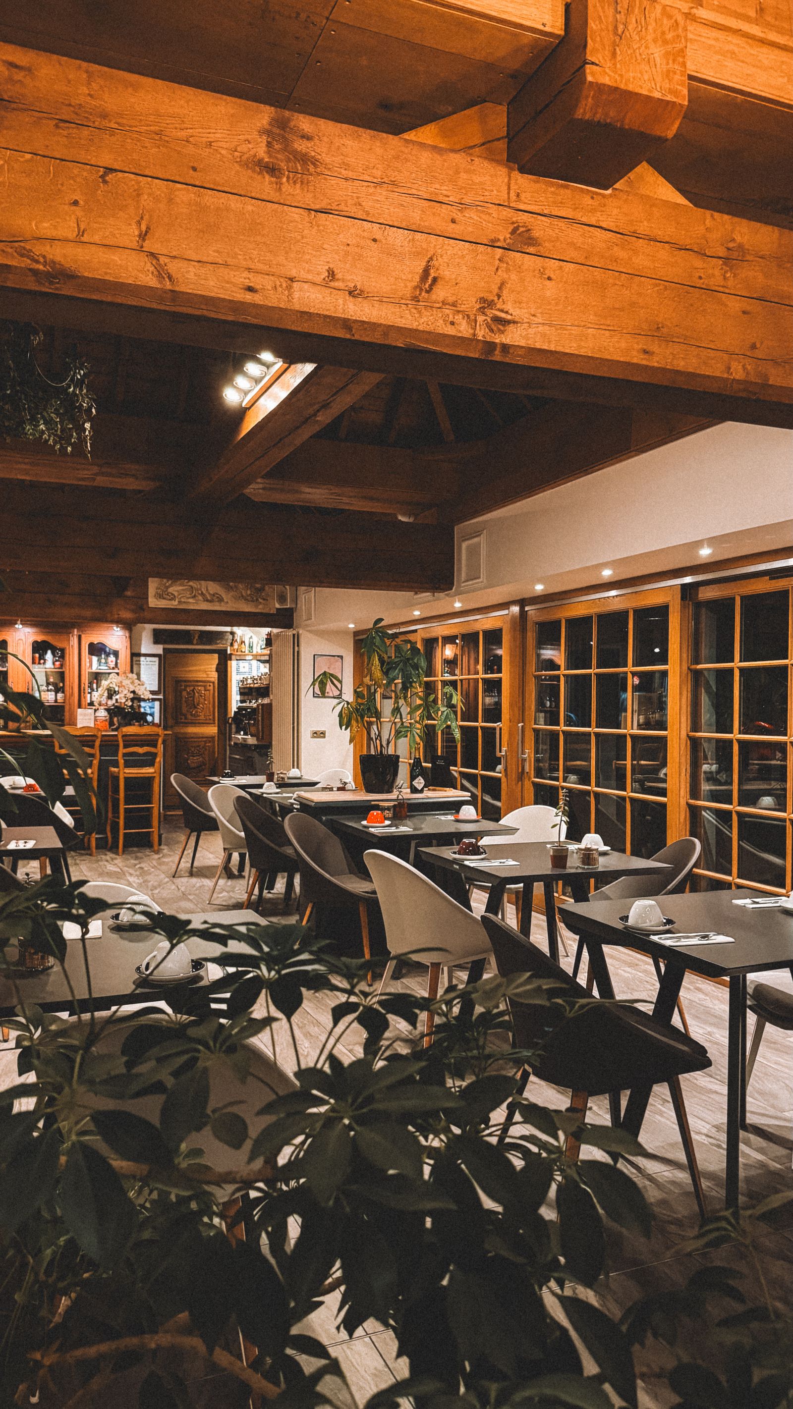Warmes, holzgetäfeltes Gasthaus-Interieur mit gedeckten Tischen